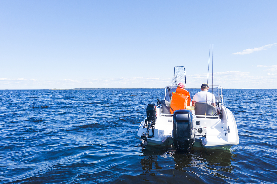 boating boater boat Fisherman on boat in blue ocean. Beautiful seascape with the fishing boat. Fishing motor boat with angler. Ocean sea water wave reflections. Motor boat in the ocean.