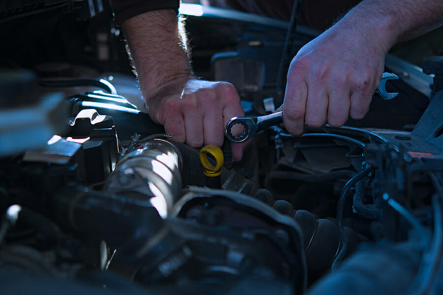 Auto mechanic working on car engine in mechanics garage. Repair service. authentic close-up shot